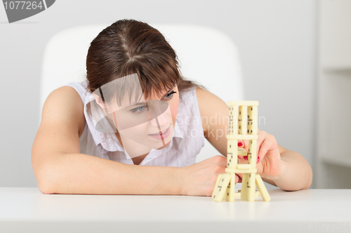 Image of Woman accurately collects construction from dominoes