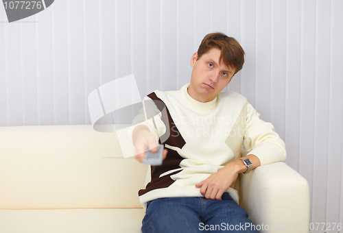 Image of Guy sits on sofa and watches TV