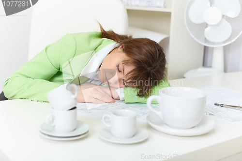 Image of Office worker has fallen asleep despite drunk by coffee