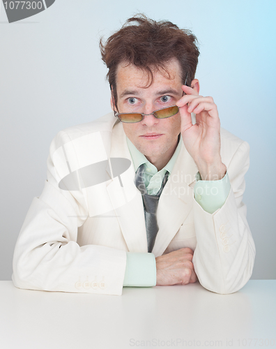 Image of Man with tousled hair sits at a table