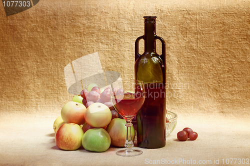 Image of Still-life - bottle of wine and fruit against a canvas