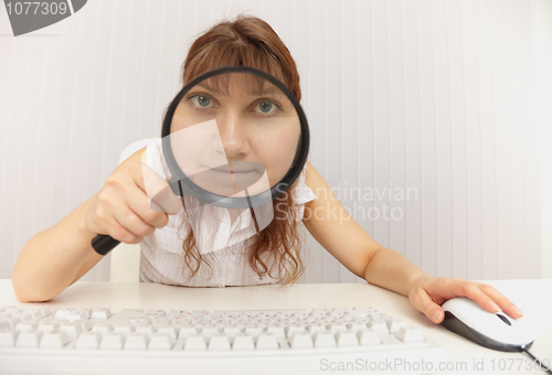 Image of Amusing girl with computer keyboard and magnifier