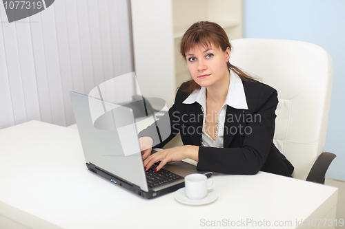 Image of Young woman works with computer at office