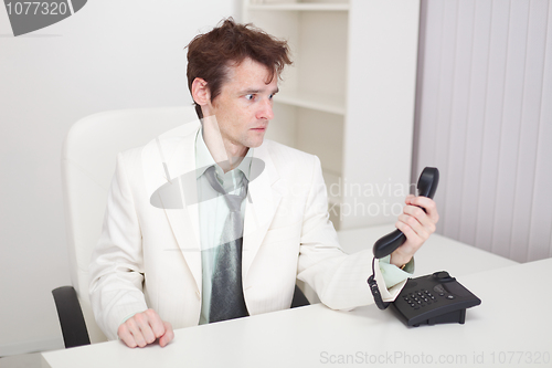 Image of Businessman has finished difficult telephone conversation