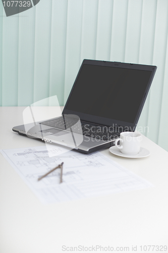 Image of Laptop on table with drawing and a compasses - business still-li