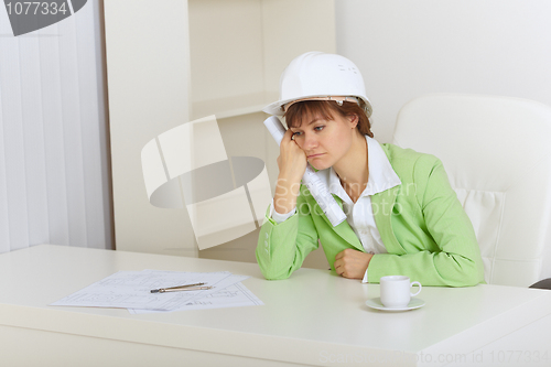 Image of Woman - construction superintendent sits upset
