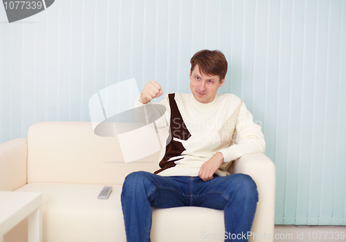 Image of People sits on sofa with remote control