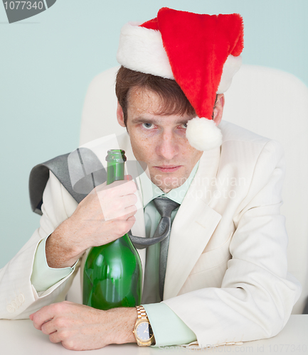 Image of Drunk and tired guy in white jacket with bottle celebrates Chris