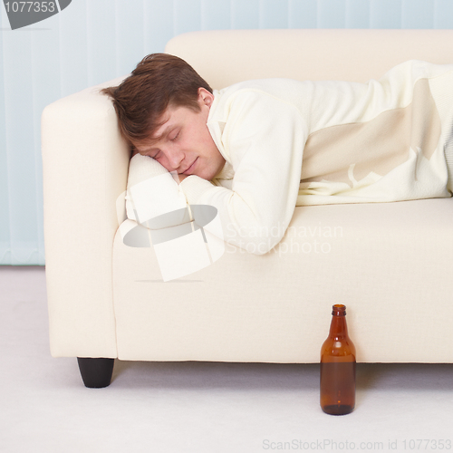 Image of Person comfortable sleeps on sofa having got drunk beer