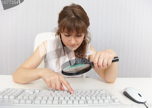 Image of Girl with poor eyesight works on keyboard by means of magnifier