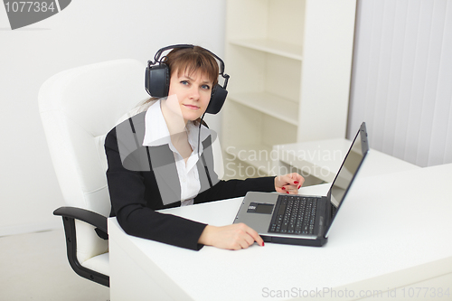 Image of Young woman with big stereos ear-phones on head