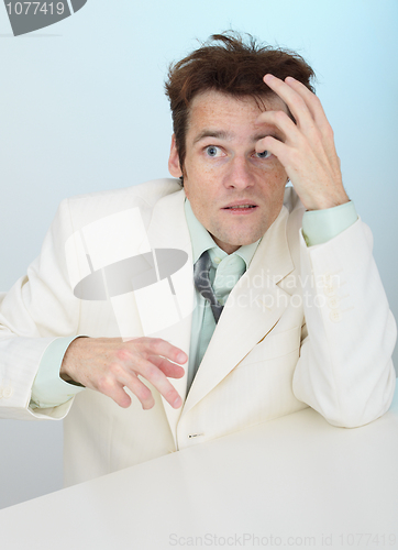 Image of Young amusing tousled scared person in white jacket