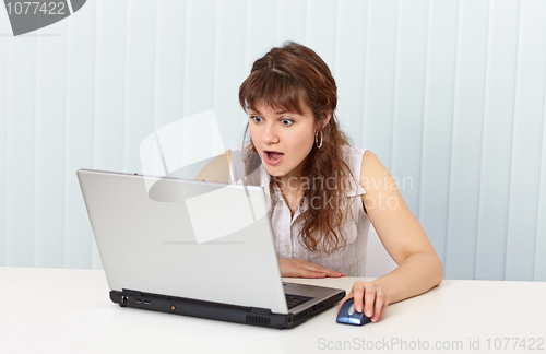 Image of Indignant woman works in Internet with laptop