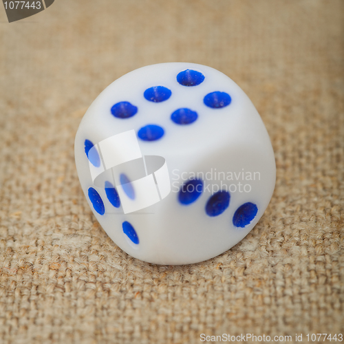 Image of Plastic dice with blue dots on canvas close up