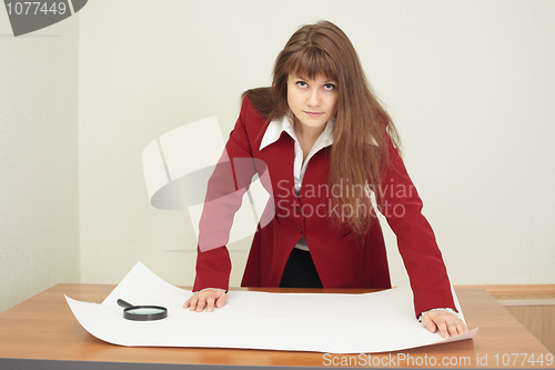 Image of Young woman - engineer works with big drawing