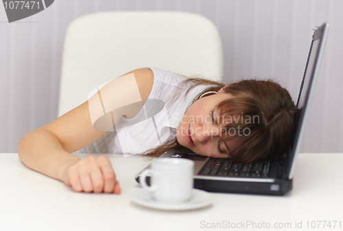 Image of Young girl sleeps on laptop keyboard