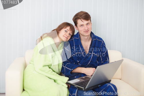 Image of Young couple on sofa with laptop
