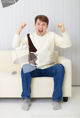 Image of Man - football fan watches the championship on TV