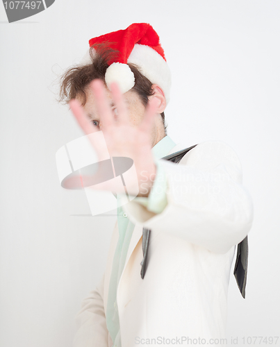 Image of Person in Christmas cap closes face a hand