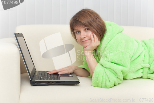 Image of Young woman with laptop on a sofa