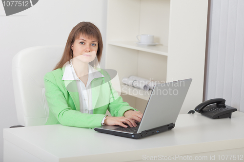 Image of Young beautiful woman - secretary sits on workplace with compute