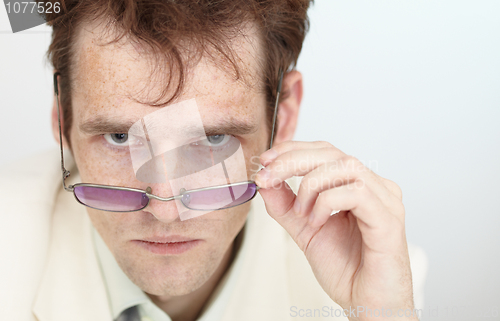 Image of Severe look of young man over spectacles