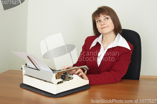 Image of Young woman works on an ancient typewriter