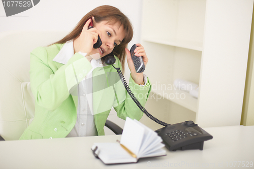 Image of Secretary speaks by several phones simultaneously