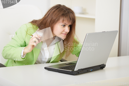 Image of Girl threateningly looks at the computer monitor