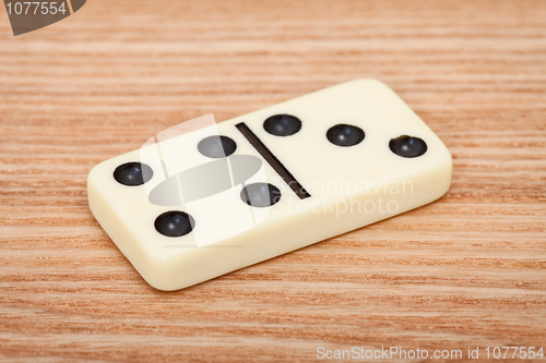 Image of One tile dominoes on wooden surface close up