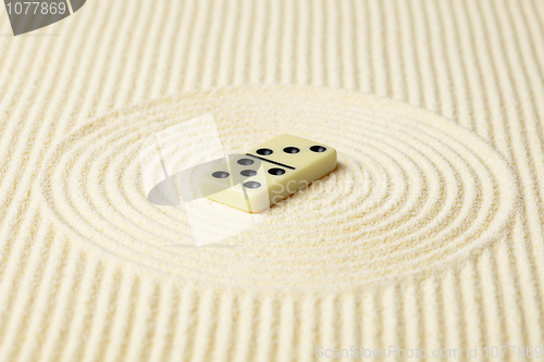 Image of Dominoes on surface of yellow sand - abstract composition