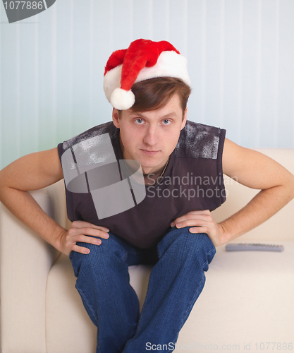 Image of Person sits on sofa in a red Christmas cap