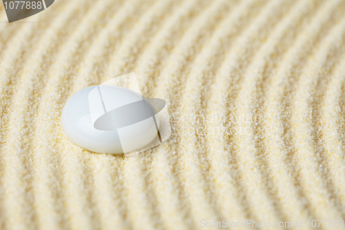 Image of Ceramic stone on a surface of yellow sand close up