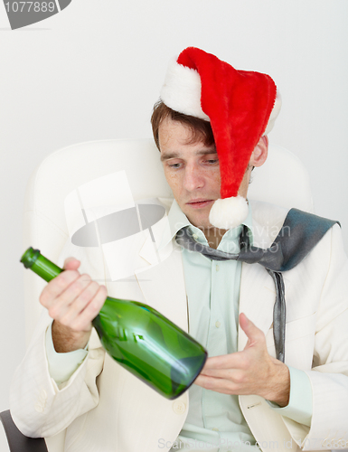 Image of Young drunkard celebrates new year with wine bottle