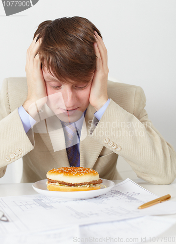 Image of Young man in an anticipation of eating of hamburger