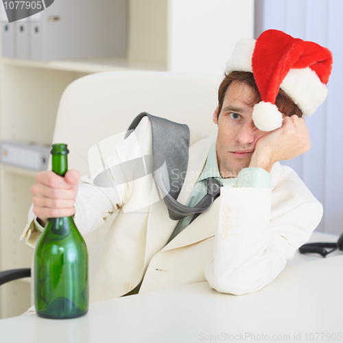 Image of Young drunkard celebrates Christmas with wine bottle