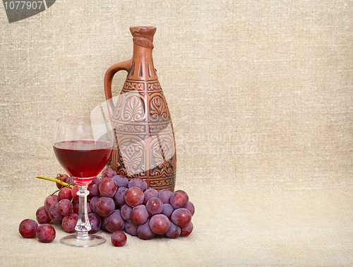 Image of Clay jug with Georgian wine, glass and grapes