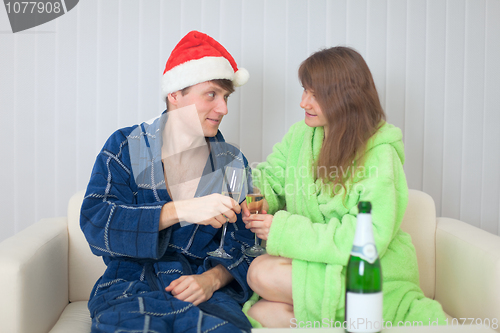Image of Young couple drinks sparkling wine in dressing gowns