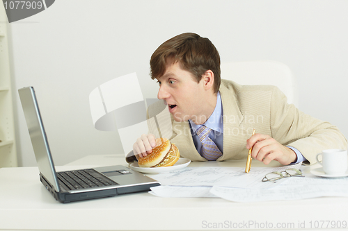 Image of Funny man with big sandwich at office
