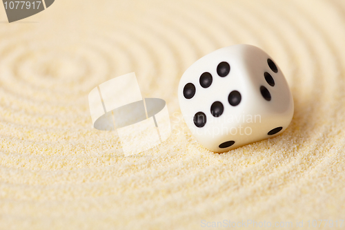 Image of Dice on sand in rock garden