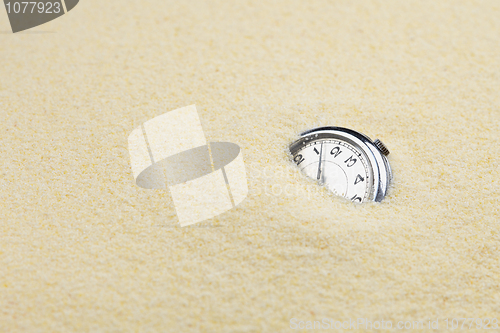 Image of Ancient mechanical watch in sand