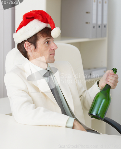 Image of Young drunkard celebrates new year with wine bottle