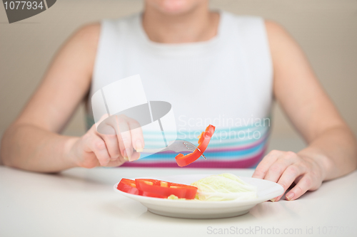Image of Woman eats vegetables keeping to strict vegetarian diet