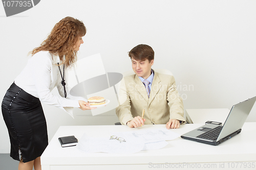 Image of Woman secretary delivered to businessman a hamburger