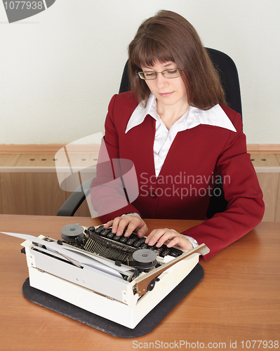 Image of Young woman works with typewriter