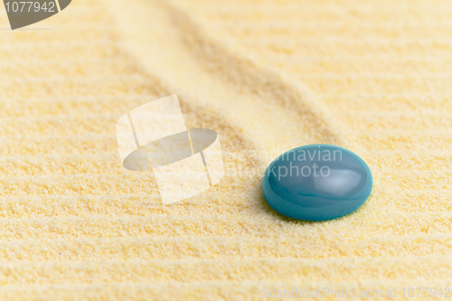 Image of Abstract composition - sandy surface and blue glass drop