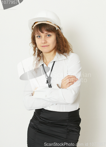 Image of Young beautiful woman in building protective helmet