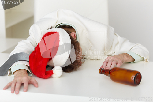 Image of Strongly drunk man in Christmas cap on table