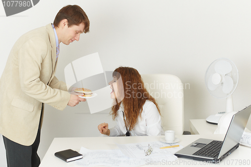 Image of Young woman comically reaches for meal during the lunchtime