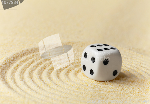 Image of Playing white dice on yellow sand - art miniature